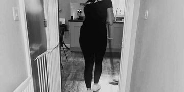 Person taking a mirror selfie in black outfit.