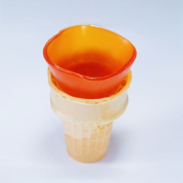 An ice cream cone filled with orange jelly instead of ice cream.