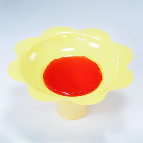 Yellow and red plastic flower-shaped bowl on a white background.