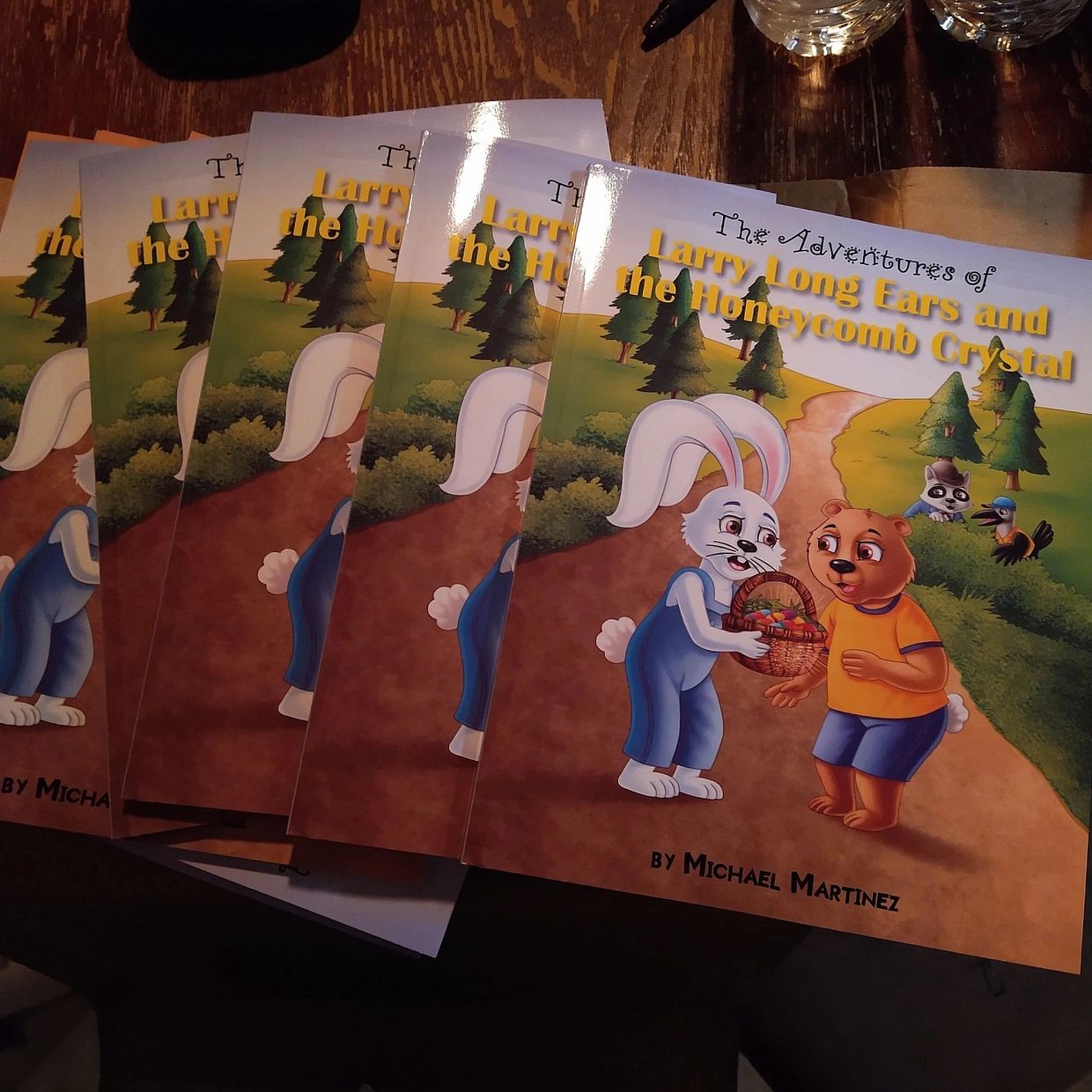 Multiple copies of a children's book titled 'Larry Long Ears and the Honeycomb Crystal'.