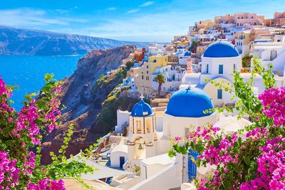 Colorful buildings with blue domes by the sea in Santorini, Greece.