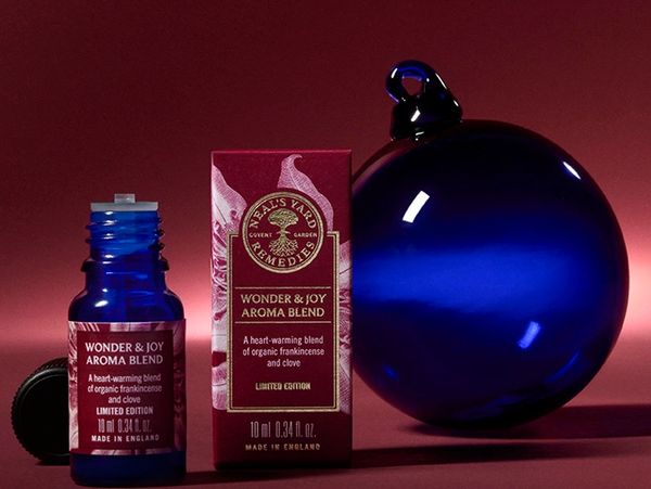 blue glass bauble next to Neal's Yard REmedies Organic essential oil blend bottle & box wonder & Joy