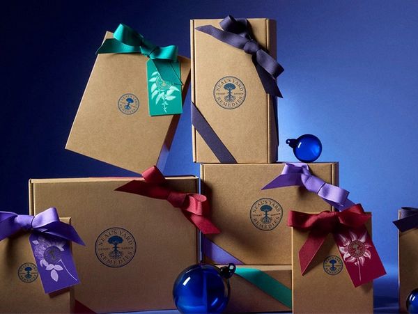 collection of brown cardboard gift wrapped boxes with Neal's Yard REmedies Log, with Christmas tree 