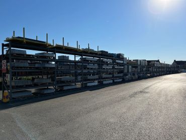 Long racks of construction materials lined up under a clear blue sky.
