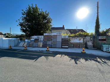 Outdoor display of various building materials under bright sunlight.