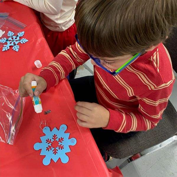 Child crafting a snowflake decoration.