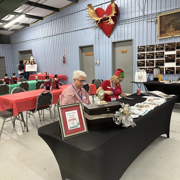Two people sitting behind a decorated table in a festive hall.