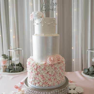 Three tiered wedding cake with buttercream and fondant details. 