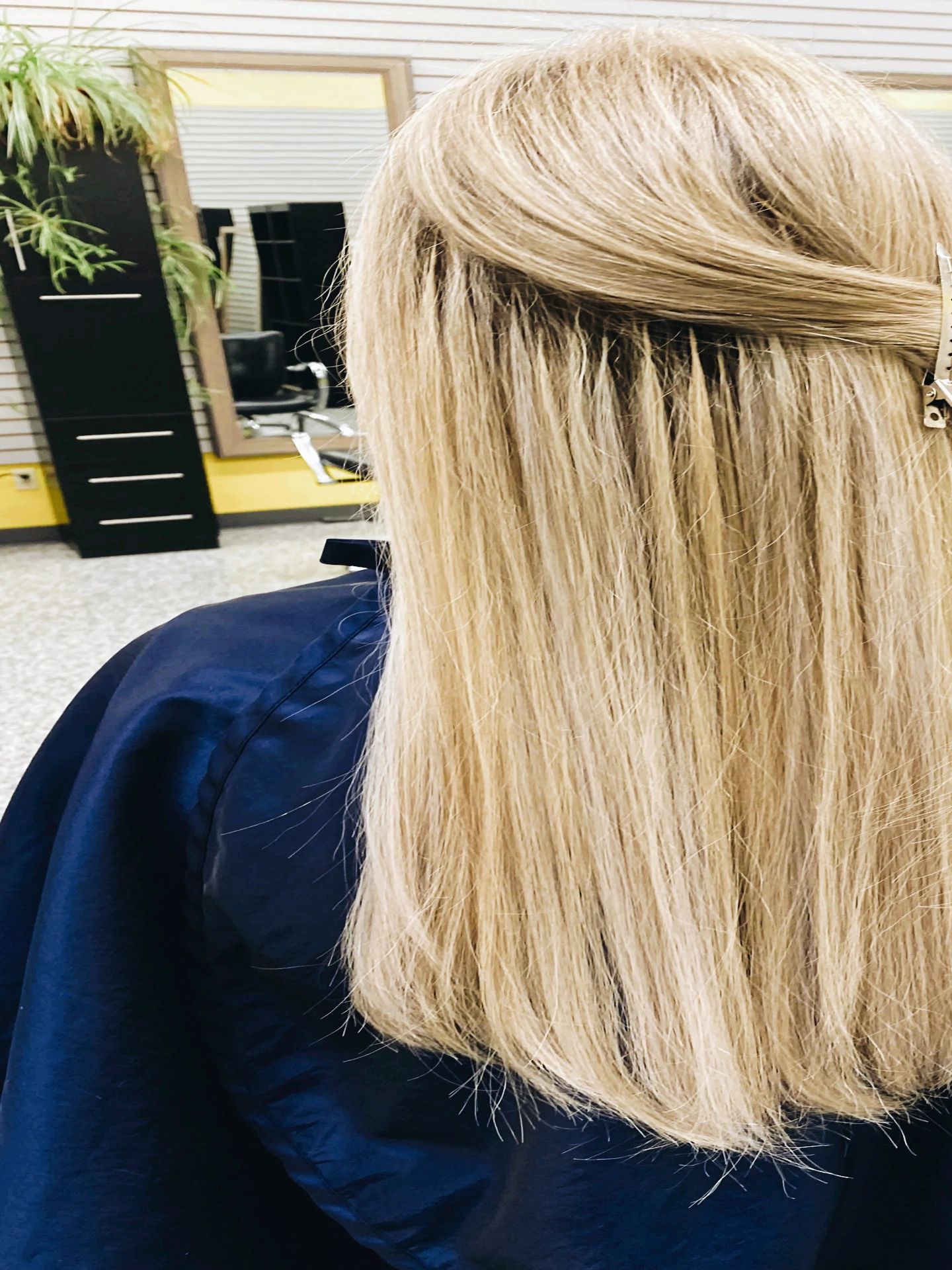 Blonde hair sectioned for styling at a salon.