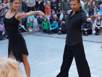A couple performing a dance routine outdoors.