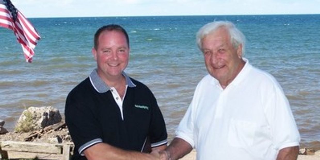 Dan Powell shaking hands with a satisfied client.