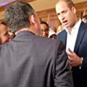 Two men engaged in a serious conversation at a formal event.