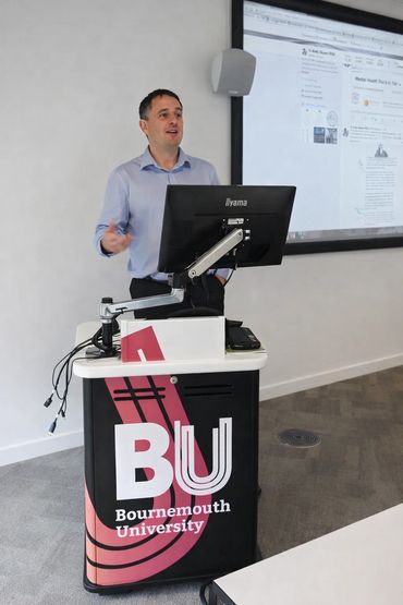 Man giving a presentation at Bournemouth University podium.