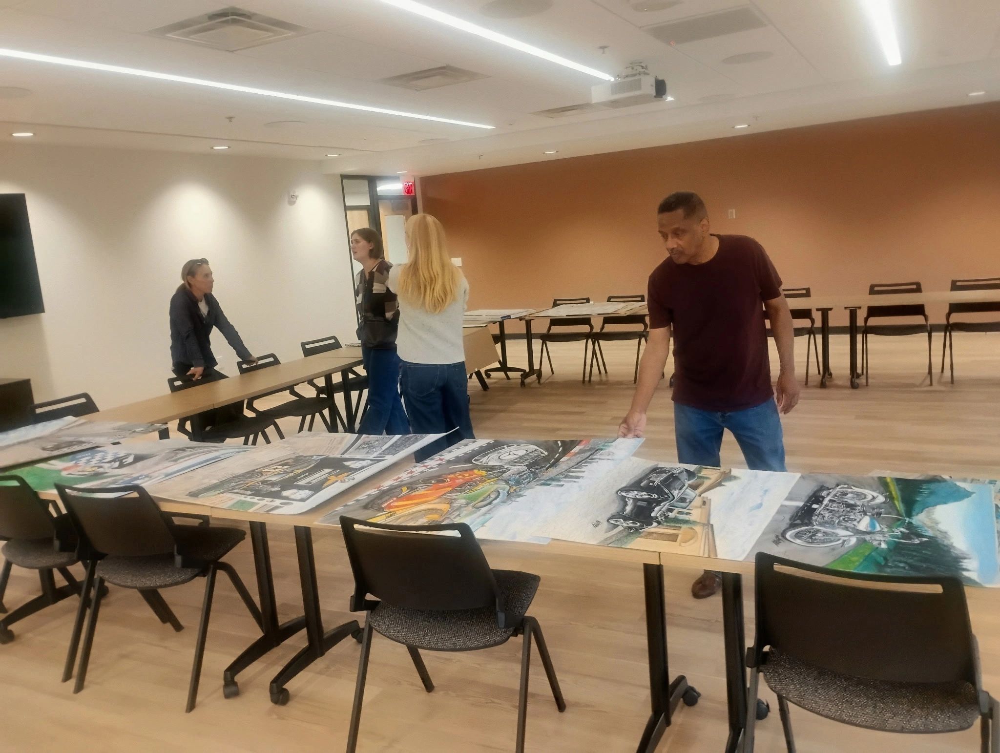 People viewing artwork in a conference room.