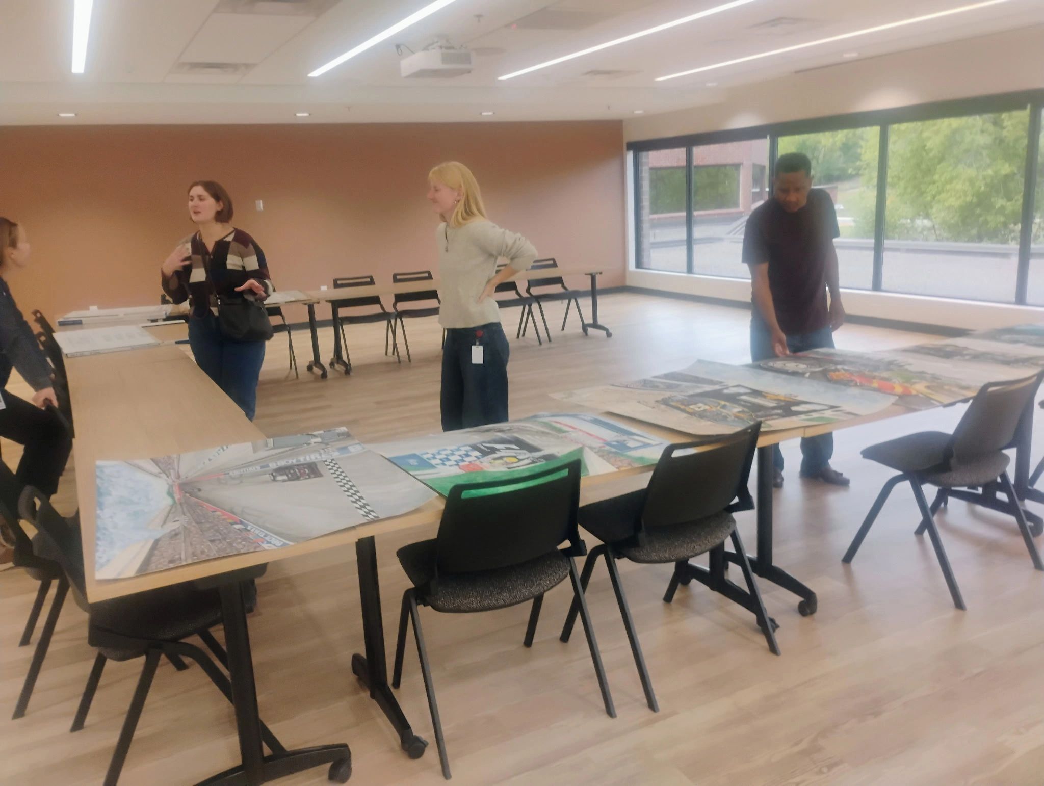 People discussing artwork in a modern conference room.