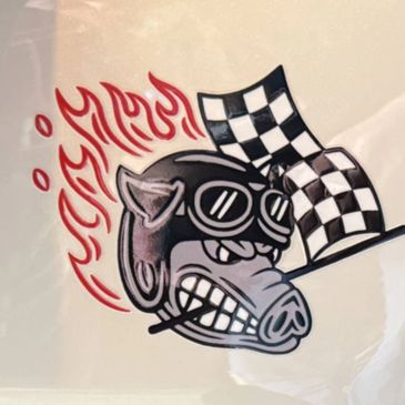 Angry pig wearing a racing helmet with flames and checkered flags.