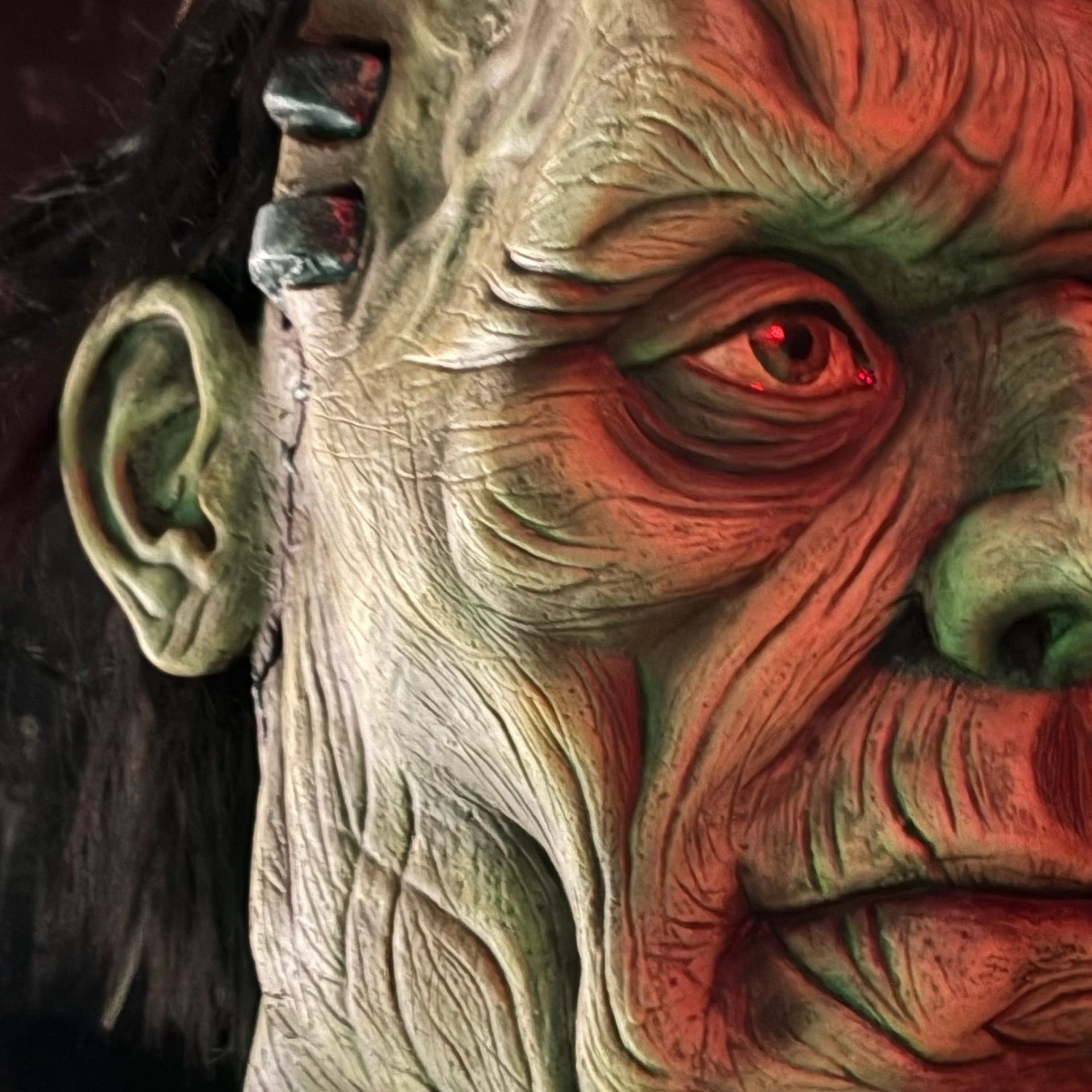 Close-up of a detailed monster or Frankenstein face with bolts and wrinkles.