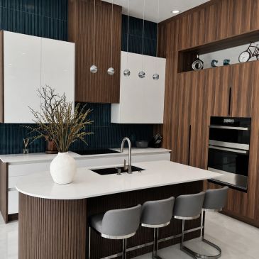 Sleek modern kitchen with wood and white finishes and a curved island.