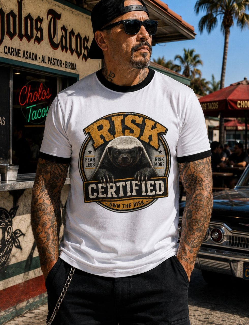 Man in sunglasses wearing a "Risk Certified" t-shirt outside a taco shop.