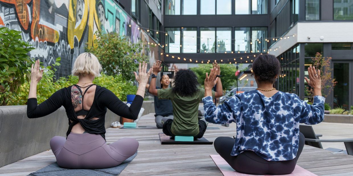 Group yoga session outdoors with diverse participants practicing meditation and balance.