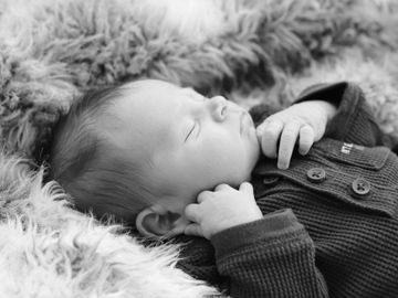 A new born baby wrapped in a blanket, black and white image.