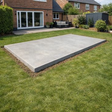 Concrete slab foundation in a backyard near a house.
