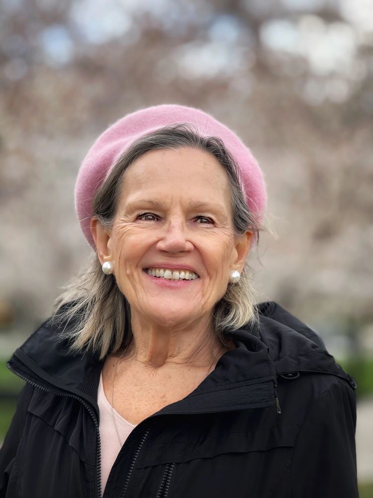 Portrait of Sandi Greene, Reinvention Life Coach, speaker, and teacher, smiling outdoors while encouraging reinvention after 50, lifelong learning, and personal growth.