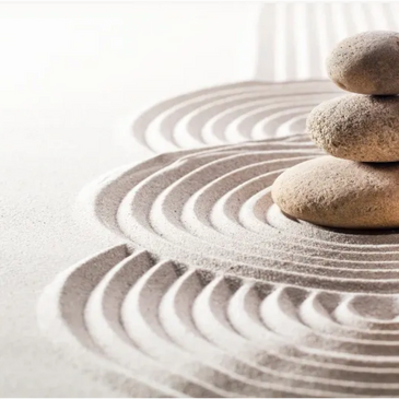 Zen garden with stacked stones and raked sand patterns.