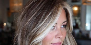 Close-up of a woman with beautifully styled blonde hair and soft makeup.