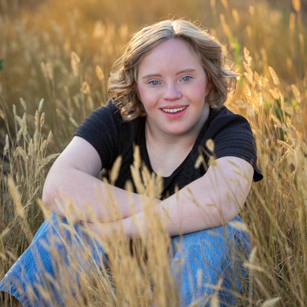 Senior girl sitting in glowing grass