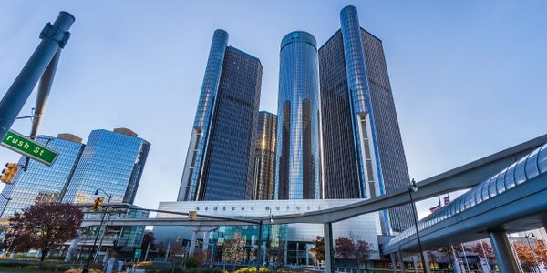 Futuristic downtown buildings with a skybridge and clear blue sky.