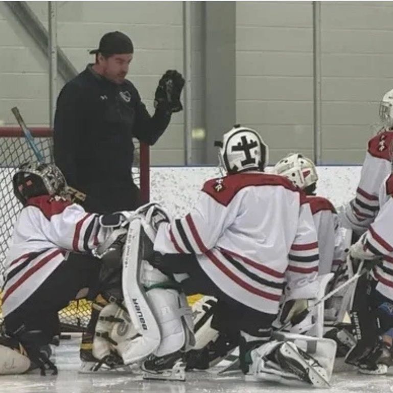 Hockey coach instructing young players.