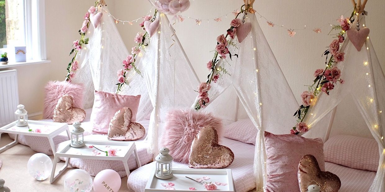 Boho Bliss teepee sleepover in pink and rose gold with floral garlands and elegant cushions