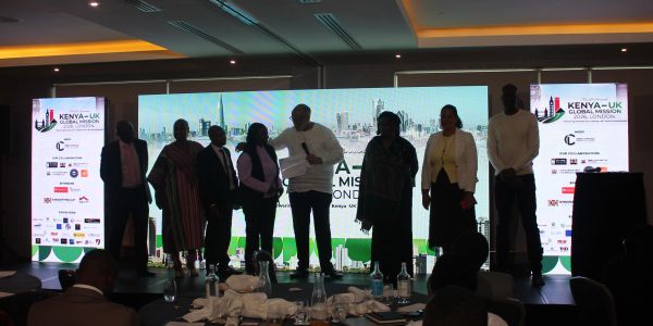Group of people standing on stage at Kenya-UK Global Mission event in London.