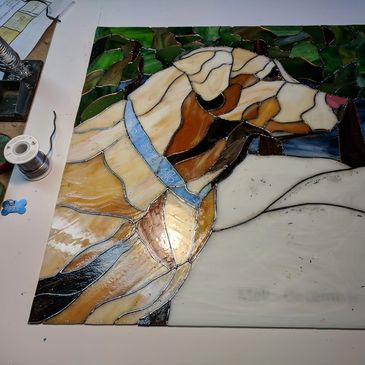 Stained glass artwork depicting a dog with a blue collar.