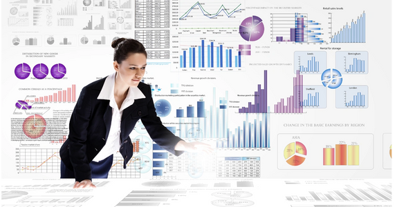 woman standing over a desk with charts and graphs in the air