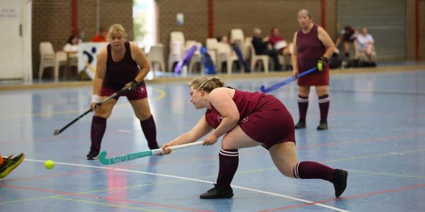 Three of our women's players in action during an indoor hockey match.