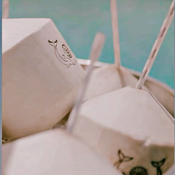 Close-up of fresh coconuts with straws.