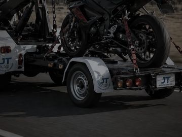 A motorcycle secured on a trailer attached to a vehicle.