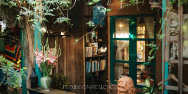 Cozy indoor garden with books, flowers, and warm lighting.