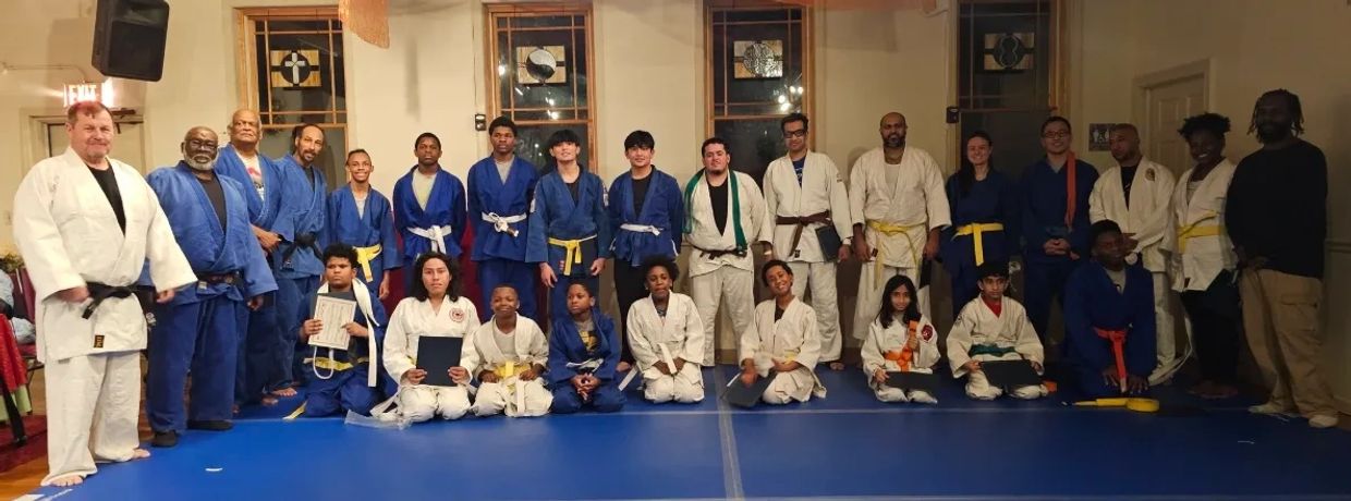 Group photo of martial artists in uniforms with belts.