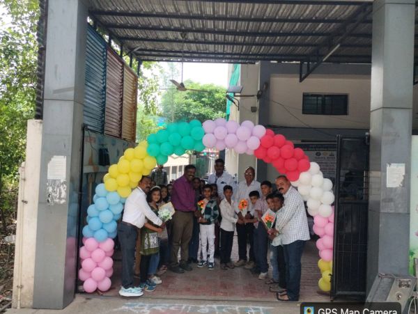 Group of people posing under a colorful balloon arch.
