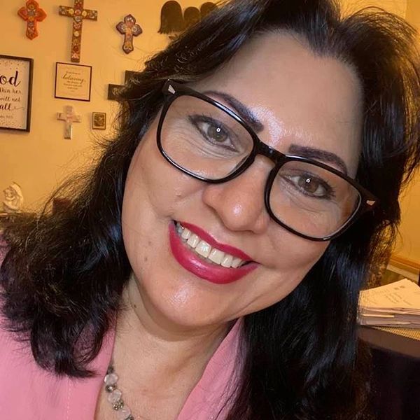 Mujer sonriente con gafas grandes y labios rojos.