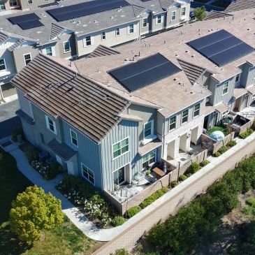 Row of modern houses with solar panels on roofs.
