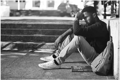 A man sits dejectedly with his hands on his head