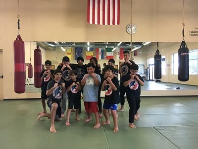 A group of kids posing in a martial arts gym.