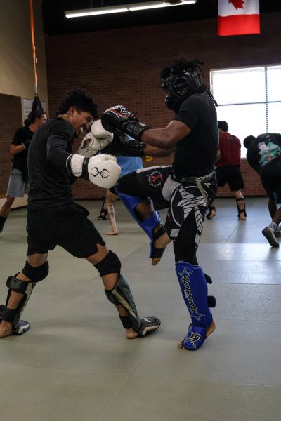Two fighters sparring in a martial arts gym.