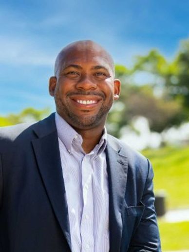 Rob Andrews in suit outside smiling