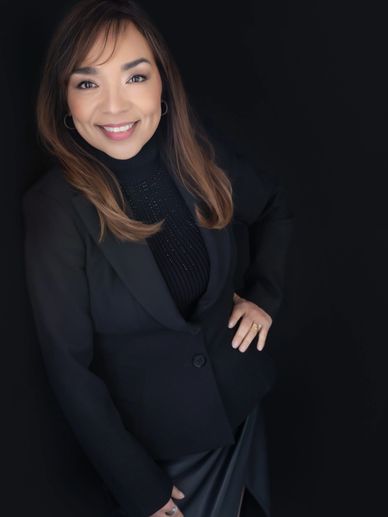 Talia Bond in black smiling with hand on hip