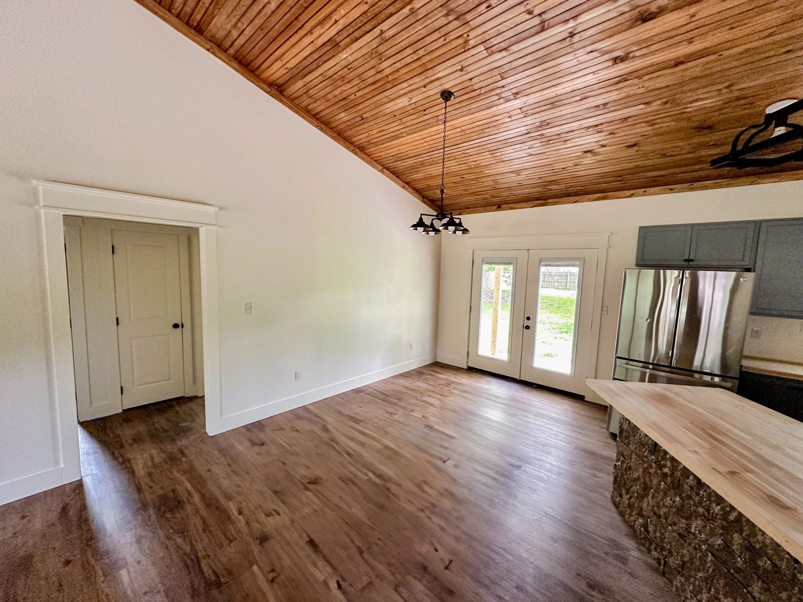 Rustic kitchen with wooden ceiling and hardwood floors.